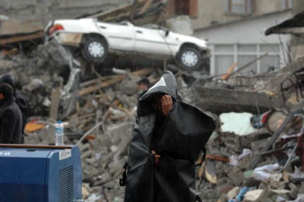 Erci'te ceset torbasyla yamurdan korunan biri (28 Ekim 2011)