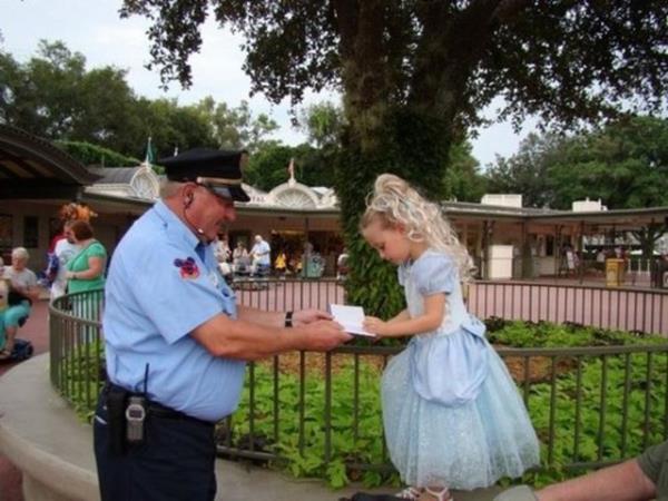 Magic Kingdom oyun parknda gvenlik grevlilerinden biri, prenses gibi grnen kk kzdan imza isterken