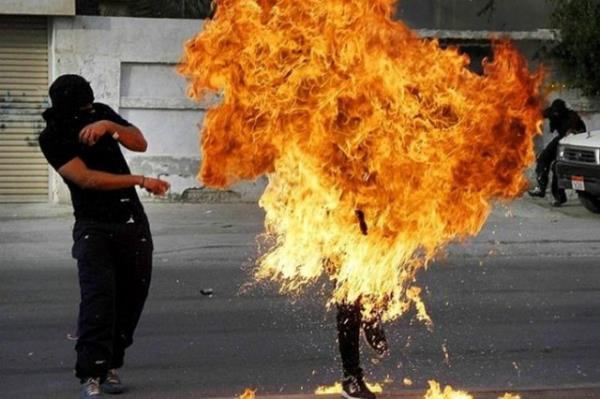 Bahreyn'li bir protestocunun elinde patlayan molotof kokteyli.