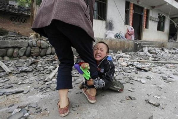 in'de 6.6 iddetinde deprem sonras evi yklan bir ocuun annesinin bacana sarlrken fotoraflanan dram