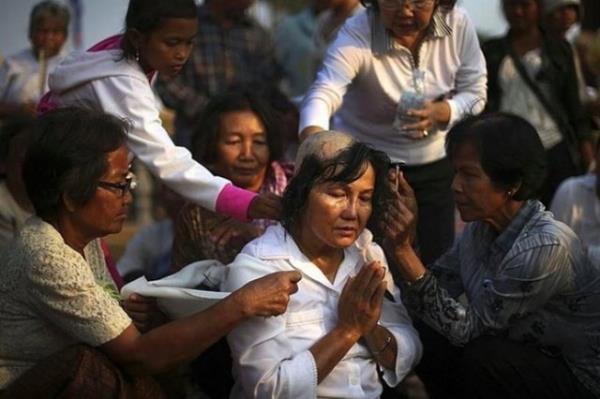 Kamboya Kral Norodom Sihanouk'un cenaze treni ncesi inanc gerei kafasn tra ettiren kadnn huzur dolu pozu