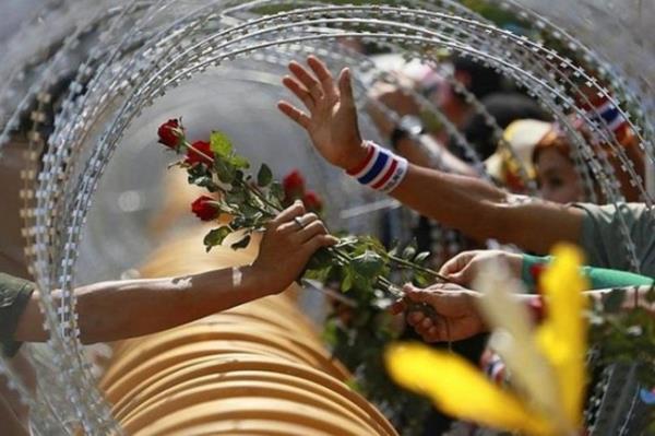 Bangkok'da hukmet kart gsterilerden, tandk bir kare. Askere iek uzatan eylemciler