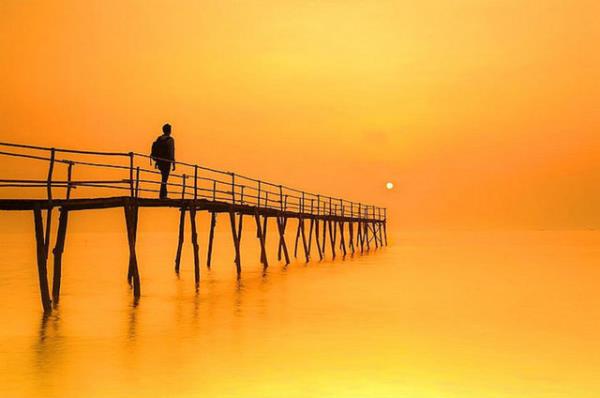Duy Nguyen tarafndan Vietnam'da ekilen bu gndoumu fotoraf, iskeledeki ocuun biraz daha ilerlediinde gnee ulaaca hissi veriyor. Oysa gne ok uzakta, iskele de ok ksa. Lakin fotoraf sanat bu; uzaklar yakn, ksalar uzun yapabiliyor.