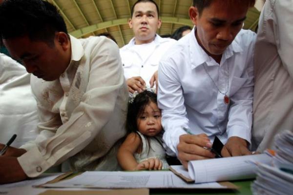 <p><b>�ubat</b></p>  Filipinler H�k�metinin Quezon City'de Konut Geli�tirme Yat�r�m Ortakl��� taraf�ndan ger�ekle�tirilen toplu d���ne kaydolmak i�in babas�yla s�raya giren bir k�z