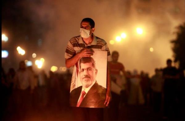 <p><b>Temmuz</b></p>  Devrik M�s�r Cumhurba�kan� Muhammed Mursi yanl�s� bir g�sterici 15 Temmuz'da Kahire'de yap�lan bir protestoda liderin posterini tutuyor.