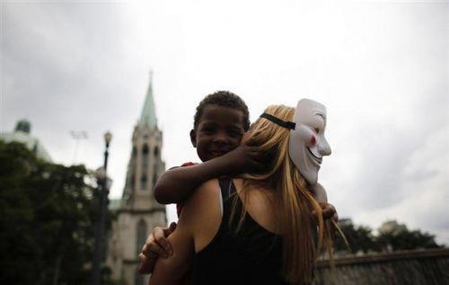 "Anonymous" yesi bir kadn, Sao Paulo'da evsiz bir ocuu kucaklarken grntleniyor. Uluslararas siber korsanlk grubu Anonymous, Noel ncesi Sao Paulo'da evsizler yararna dzenledikleri etkinlikte bedava yiyecek ve kyafet datt. Brezilya