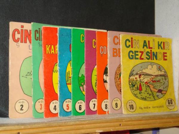 <p><b>CN AL OCUK KTAPLARI: </b></p>  1970`lerde revata olan ilkokul ocuklarna ynelik "Cin Ali" adl kare eklinde 16 sayfadan oluan, siyah-beyaz ok enteresan kitaplar vard. Ali adl ocuun, belli bir seriyi takiben; okuldaki, piknikteki, denizdeki, mzedeki, trendeki, diideki ve hayvanat bahesindeki mthi heyecanl (!) maceralarna yer veren kitaplardaki izimler p izgilerden olumaktayd. Herey ama herey birka izgiden ibaretti; evler, arabalar, insanlar, hayvanlar, eyalar... Kollar ve bacaklar ve vcutlar pten ibaret olup herhangi bir organ ihtiva etmemekteydi. Kafalarsa bir yuvarlaktan mteekkildi. Okuyan ocuun resimleri kolayca taklit ederek izebilmesine imkn vermek amacyla dnld muhtemeldi. Her ocuun antasnda bu serinin en az 1-2 kitab mevcuttu. 80`lerden itibaren ocuk kitaplar sektrndeki hzl geliim, Cin Ali kitaplarnn da sonu oldu.