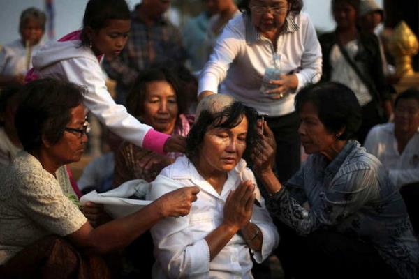 Kral Sihanouk geiini anmak iin Kamboya'da bir kadn kafasn tra etmitir.