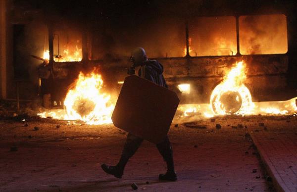 Avrupa yanls bir protestocu, Kiev'de hkmet idaresi binalar yaknnda bir miting srasnda yanan bir polis otobsnn yanndan yrrken. Gleb GARANICH / REUTERS