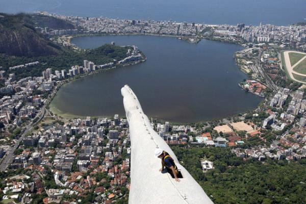 Bir ii,Rio de Janeiro'da yaanan yldrml frtnalar sonrasnda hasar gren Mesih heykelini incelerken STRINGER/BRAZIL/REUTERS