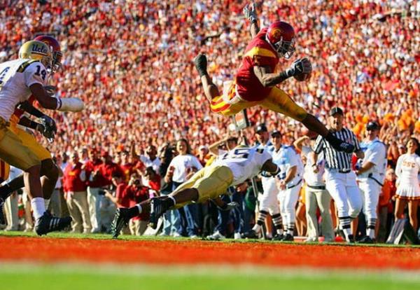 USC?li Reggie Bush?un, UCLA?in savunmaclarndan Marcus Cassel?in zerinden atlayarak touchdown izgisine ulat an...