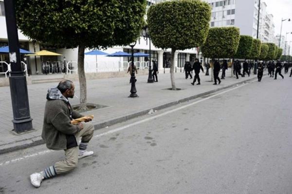Arap Bahar srasnda Tunus`ta yaanan olaylarda bir protestocun polislere kafa tuttuu an..