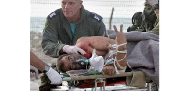 <p><b>AFP</b></p>    Gney Lbnan'da yaralanan srail askeri hastaneye giderken gazetecilere zafer iareti yapyor...