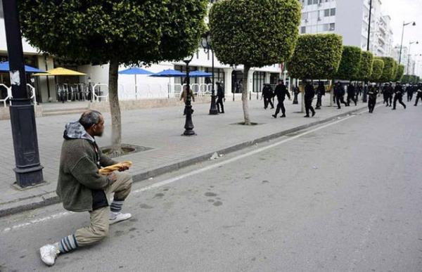 Bir adam, Tunus Devrimi srasnda evik kuvvet polisiyle yzleiyor. (2012)