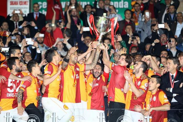 Konya'da, 9 yl aradan sonra 15. kez kupay kazanma baars gsteren Galatasarayl oyuncular, kupay taraftarlarnn bulunduu tribne gtrerek sevin gsterilerine burada devam etti. El ele tutuup kaleye doru koan ve yere yatan oyuncular, kale arkasndaki basn mensuplarna ampiyonluk pozu verdi.