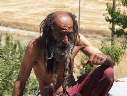 G�zleri de di�leri de �ok sa�lam. Ancak kesinlikle kimsenin g�z�n�n i�ine bakm�yor. Eski arkada�lar�ndan ya da tan�d�klar�ndan birinin �ld���n� duydu�u zaman hemen yerinden kalk�p bir takla at�yor. Niye yapt���n� sordu�umuzda ise "Bu da benim onlar i�in yapt���m ibadetim" diyor. Bir ara s�caktan bunal�p �st�ndeki y�rt�k kaza��n� da ��kard���nda sa�� ve sakal� daha da ortaya ��k�yor. Bir gram ya� yok ama �yle bir deri bir kemik durumu da yok. Anlat�lanlara bak�l�rsa 40-50 kiloluk hurday� kilometrelerce ta��yabiliyor.