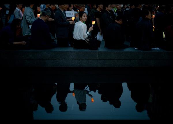 Gney Koreli bir kadn lkenin gneybatsnda sulara gmlen 'Sevol' isimli feribotta hayatn kaybedenler ansna bir mum yakm... 16 Nisan'da yaanan felaket sonras 270 kiinin cesedine ulald. 30 yolcunun cesedini arama almalar halen devam ediyor.