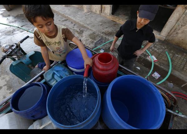Su kesintisinin bir haftadan fazladr devam ettii Suriye'nin Halep kentinde, ocuklar kuyudan kovalara su doldurarak evlerine tayor.