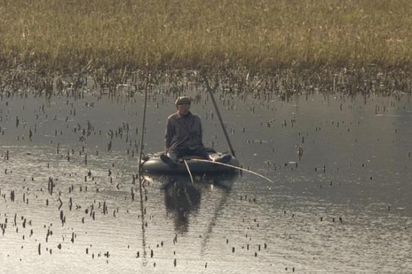 Eski bir tekerlei kendisine bot yapan bu adam, balk tutup taze yiyecek bulmann peinde.