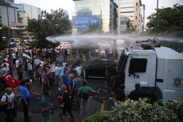 Levent Bykdere Caddesi'ndeki konsolosluun bulunduu plazann nnde bekleyen yaklak 100 kiilik grup, dualar okuyarak protestolarn srdryor.