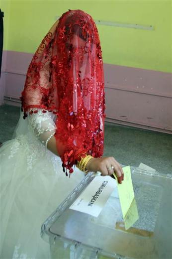 Sivas'n Hafik ilesinde damat Okan zbek (22) ve gelin Aye aldran (19) ifti en mutlu gnlerinde cumhurbakan seiminde oy kulland. Gelin adet gerei yzn ilk ei grecei ve yz grml alaca iin krmz duvan amadan oy kulland.