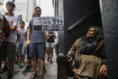 Evsiz bir adam, Hong Kong'da protesto gsterisi dzenleyen rencileri byle izledi.
