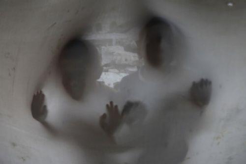 Filistinli genler, yklan duvarlarnda yerine ekilen bez duvarlarn ardndan bakyor...