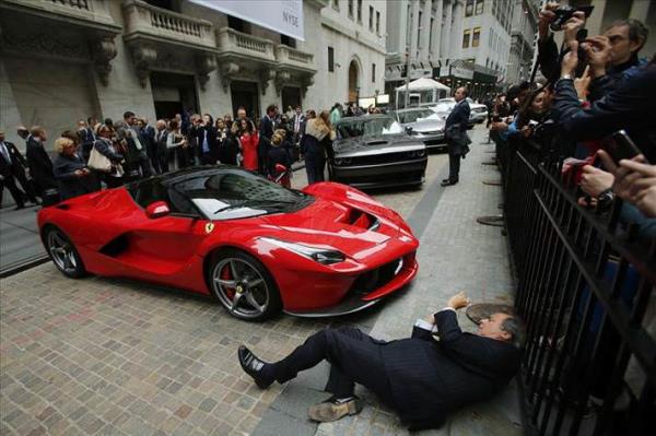 ABD Bir adam New York Borsas� �n�nde park etmi� Ferrari'nin foto�raf�n� �ekiyor. Binan�n �n�nde farkl� markalara ait onlarca ara� sergilendi.