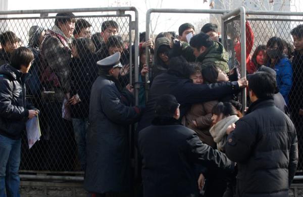 Snava kaydolmak iin sra bekleyen rencileri polis engellemeye alyor.