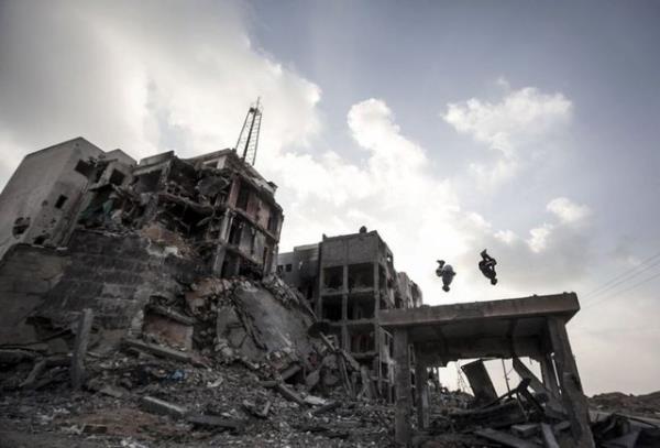 Filistinli genler, Gazze'nin kuzeyindeki Beyt Lahya kentinde srail saldrlar nedeniyle yklan evler arasnda parkur sporunu icra ediyor. 18.10.2014