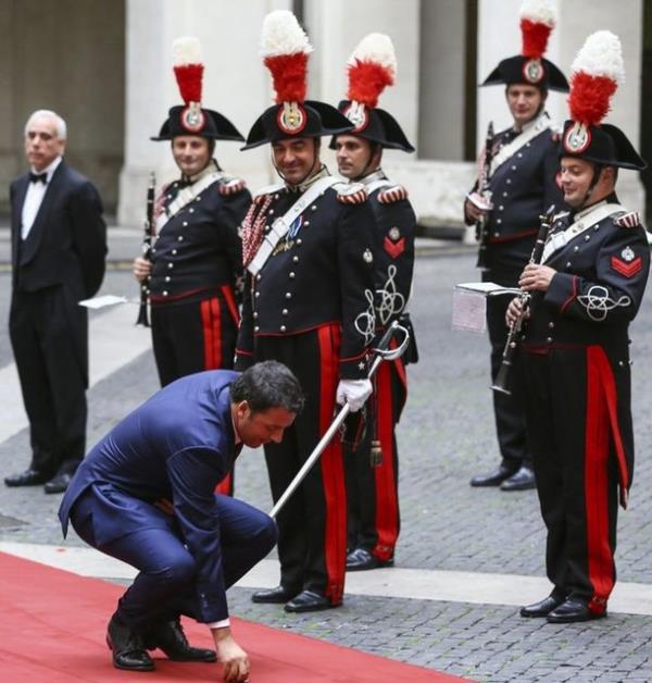 talya Babakan Matteo Renzi, in Babakan Li Kiang' Babakanlk Saray'nda karlamas ncesinde tren ktasyla sohbet ederken krmz hal zerinde grd iplik parasn yerden ald. 14.10.2014