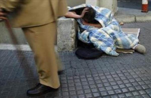 Madrid'de battaniyeye sarlarak uyamaya alan bir evsiz.