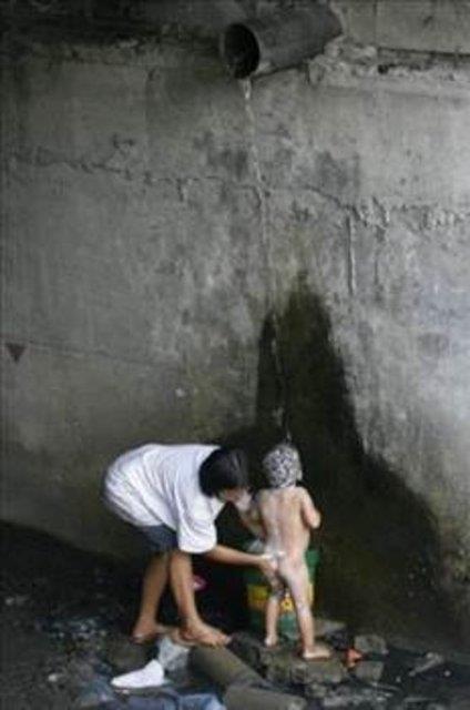 Hintli anne ebeke borusundan akan suyla cocuunu ykyor.