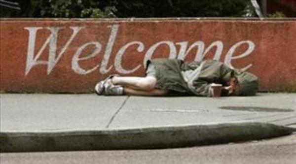 nnde bo kahve kutusu bulunan Kolombiyal evsiz kadn, kaldrm zerinde uyuyor.