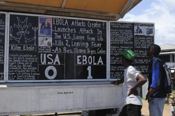 Yerli halk, Daily Talk'un (yol kenarndaki kara tahta gazetesi) Ebola:1 Amerika:0 manetini okuyor. (Monrovia - Liberya, 16 Ekim 2014, REUTERS/James Giahyue)