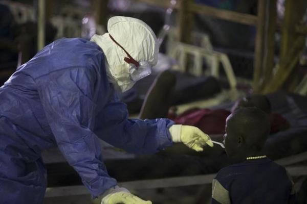 Monrovia'daki Island Klinii'nde koruyucu ekipman giymi bir salk alan, Ebola tedavisi gren bir hastaya yemek veriyor. (Liberya, 30 Eyll 2014, REUTERS/Christopher Black/WHO)