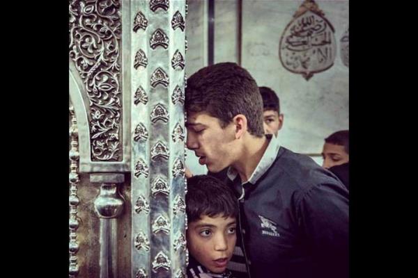 Suriyeliler am'daki Emevi Camii'nde Hz. Muhammed'in torunu Hseyin'in kafasnn yer ald metal kapnn nnde dua ediyor.   <br>Photo: @SERGEYPONOMAREV</br>