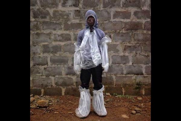 Liberya'nn bakenti Monrovia'da bir adam kendisini Ebola'dan korumaya alyor.   <br>Photo: @BCSOLOMON</br>