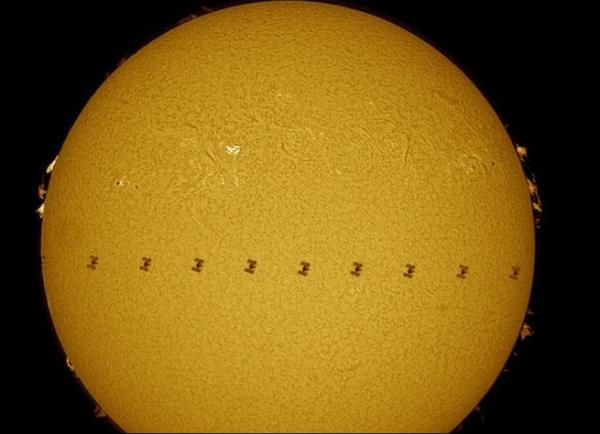 Bir dizi farkl pozun montajndan oluan bu fotorafta Uluslararas Uzay stasyonu Gne ve Dnya arasndan geerken grlyor. Bu grntde Uluslararas Uzay stasyonu, Dnya'ya Gne'ten daha yakn, bu nedenle de olduka byk olduu izlenimi veriyor. Gerekte stasyon bir futbol sahas byklnde, Gne'in ap ise Dnya'nn 100 kat.