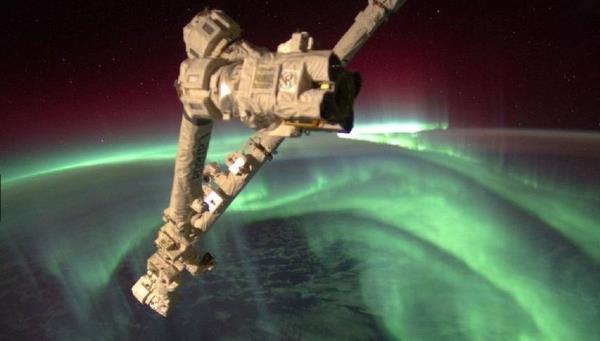 Gneten gelen ve Dnya'nn manyetik alanna ulaan patlamalar, 'aurora' ad verilen renkli ve hareketli bir maya neden olur. Bu maya Gne'in etkinlii sonucu atmosfere girip, yerin manyetik alanyla etkileimde bulunan ykl paracklar neden oluyor ve daha ok Dnya'nn manyetik alannn gl olduu kutuplarda gzleniyor. Bu fotoraf, Uluslararas Uzay stasyonu'nun mrettebat tarafndan ekildi.