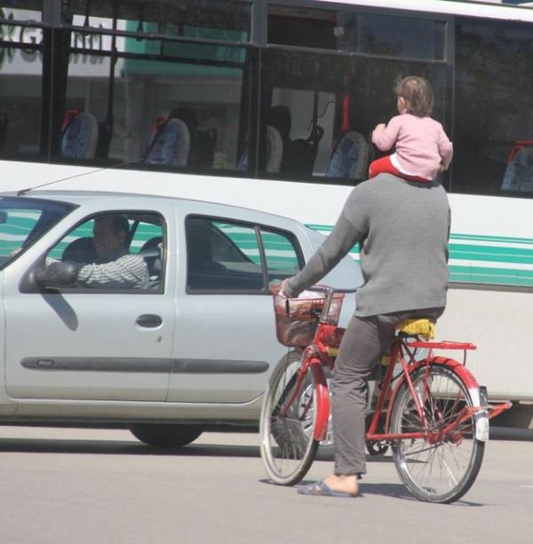 Olay , Merkez Seyhan ilesine bal Baraj Yolu Caddesi'nde meydana geldi.Bir kii ocuu olduu iddia edilen kk kz omuzlarna alarak bisiklet srd.
