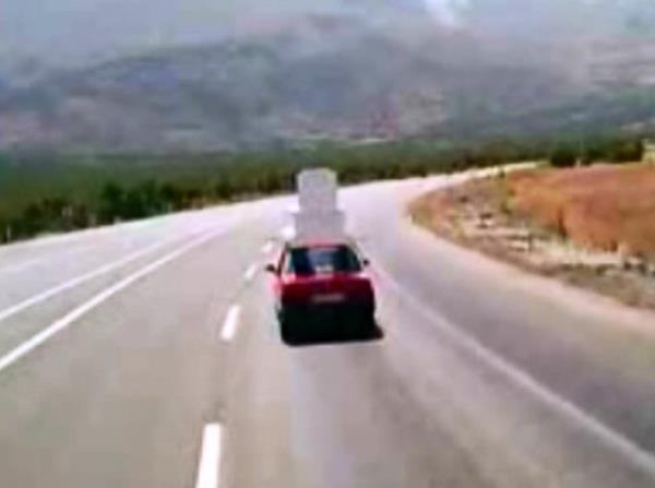 Otomobilin zerinde tanan mezar karsnda grenler, "Mezar yola dm" esprisini yaptlar.