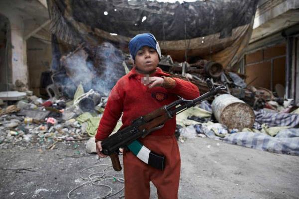 7 yandaki Ahmet elinde silahyla Halepte ki zgr Suriye Ordusu Kalesi'nin nnde duruyor.