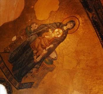 Mozaiklerin Açıklamaları  <br>  Apsis Yarım Kubbesindeki Mozaik  <br>  Altın zemin üzerinde ortada değerli taşlarla süslü tahta oturan Meryem, kucağında İsa ile birlikte tasvir edilmiştir. Meryem&#8217;in koyu lacivert renkte sade ve bütün vücudunu örten kıyafeti, etrafını çeviren altın zemin ile bir kontrast oluşturur.