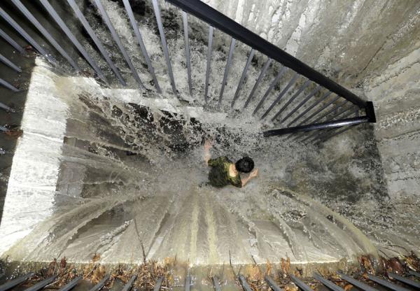 Yer altna inen merdivenlere akan su yznden aa inmekte zorlanan bir insan.