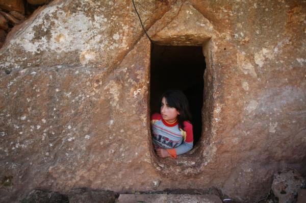 9 yandaki Nihal, Suriye'de devam eden savatan korunan sivillerin bulunduu bir lahitte, pencereden dar bakarken.