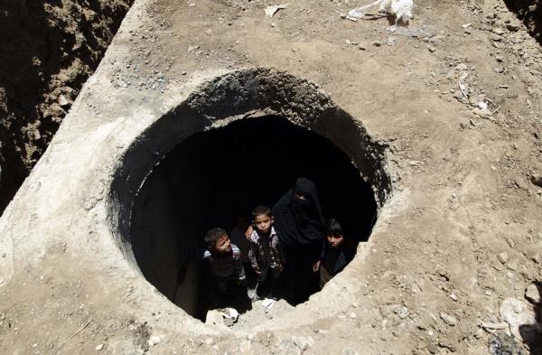 Sava srasnda evleri ykld iin bir su ukurunda yaan Yemenliler.