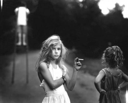 Candy Cigarette - 1992<br>    Fotoraf Sally Mann&#8217;in &#8216;Candy Cigarette&#8217; isimli almas, sanatnn model olarak kendi ocuklarn kulland &#8216;Immediate Family&#8217; serisinden. Fotorafta grnen kz ocuu, Sally Mann&#8217;in kendi kz. Fotoraf serisi, kitap olarak yaynland yl, ocuk modellerin masumiyetini yorumlama biimi ile tartmalara neden oldu
