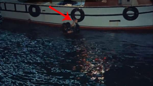 Baygn olan gen kz da can simidine tutunarak tekneye kmaya almaktadr...